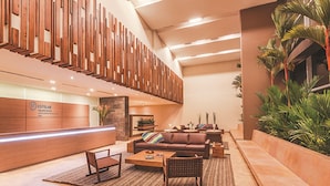 A modern lobby with a reception desk, seating area, and a staircase. - Estelar Villavicencio Hotel & Centro de Convenciones (Villavicencio)