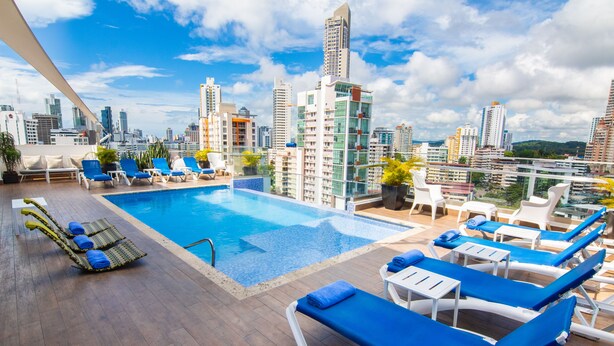 A rooftop pool with blue lounge chairs and a city skyline view. - Best Western Plus Panama Zen Hotel (Panama City)