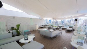 A modern lounge area with sofas, tables, and a city view. - Best Western Plus Panama Zen Hotel (Panama City)
