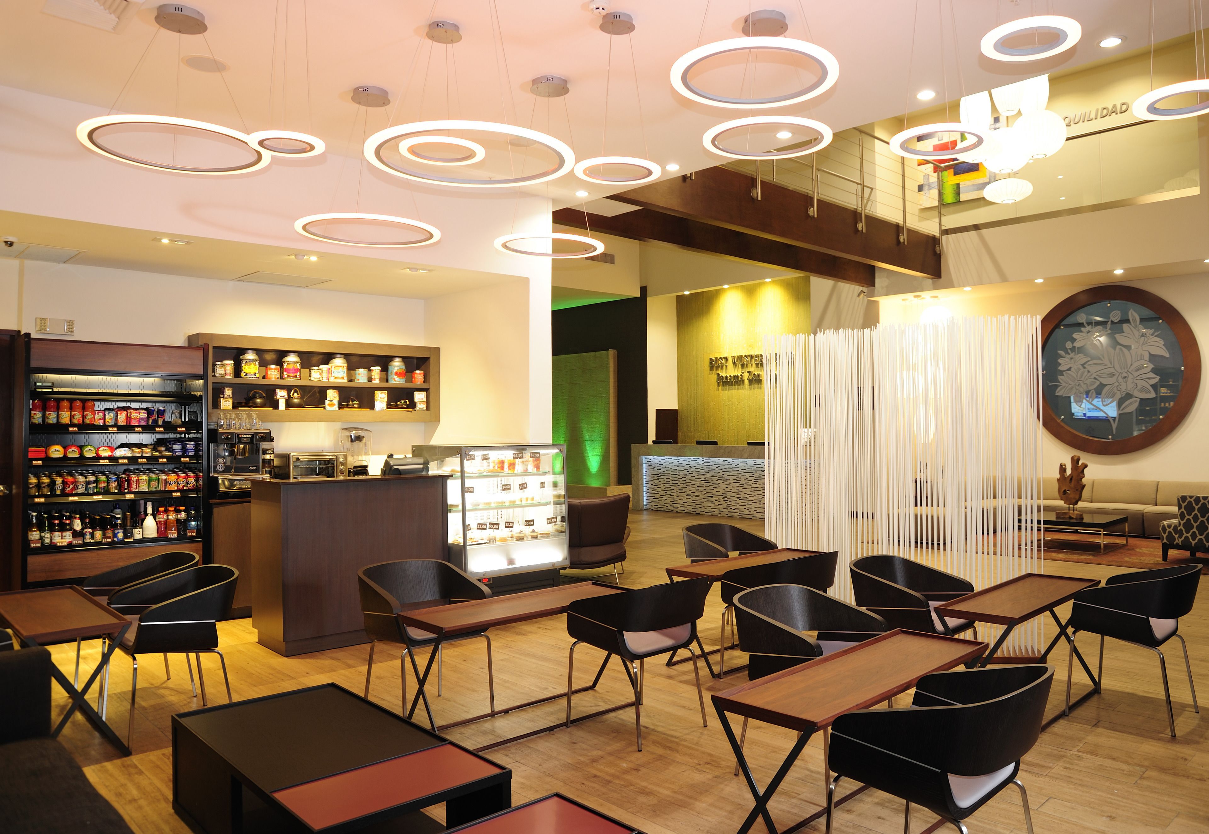 A modern restaurant with a bar area, seating, and a counter.