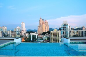 Ein Pool auf dem Dach mit Blick auf eine Stadtlandschaft.