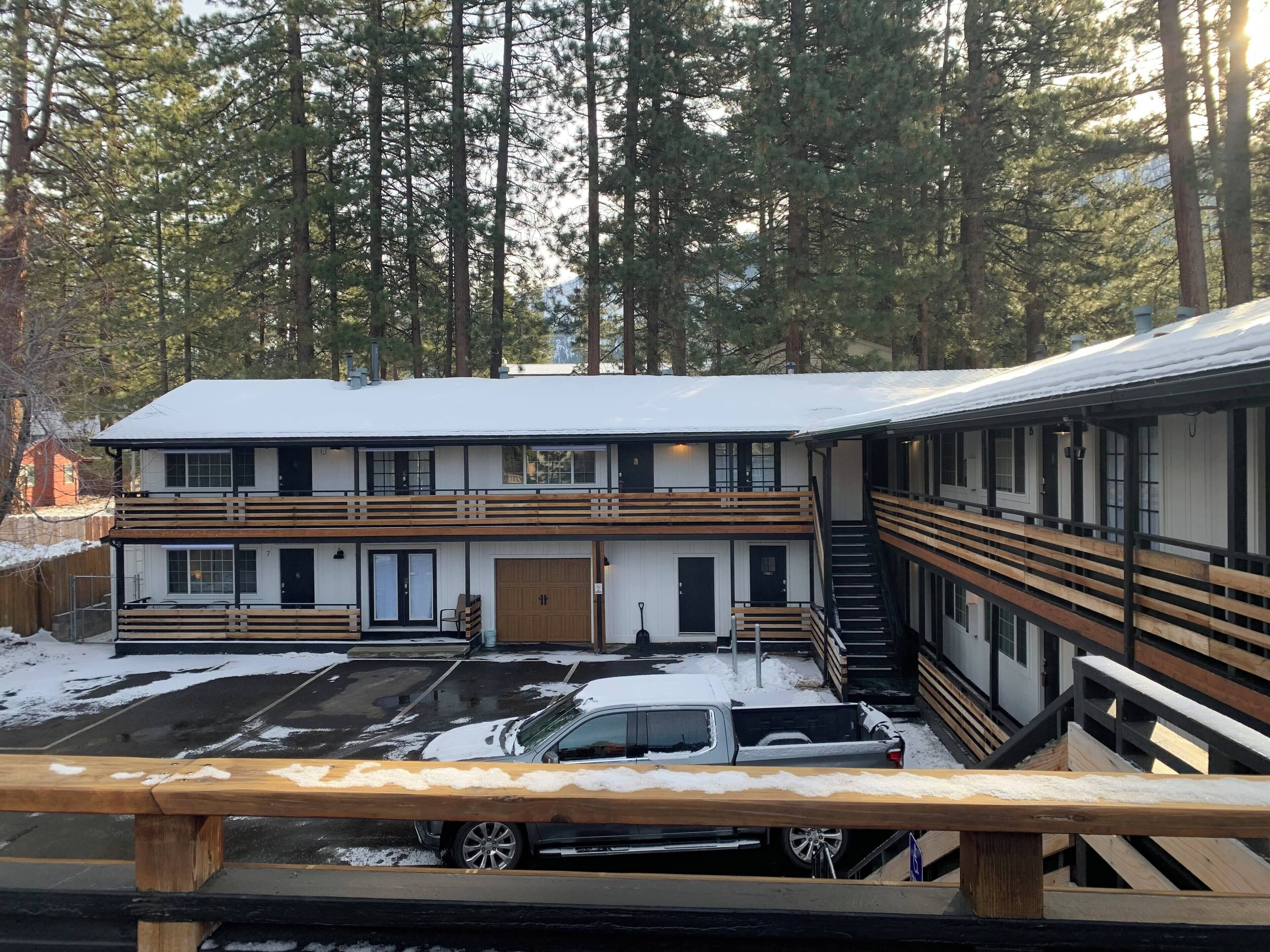 A two-story lodge with a covered parking area and a staircase leading to the upper level.