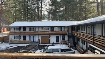 A two-story lodge with a covered parking area and a staircase leading to the upper level.