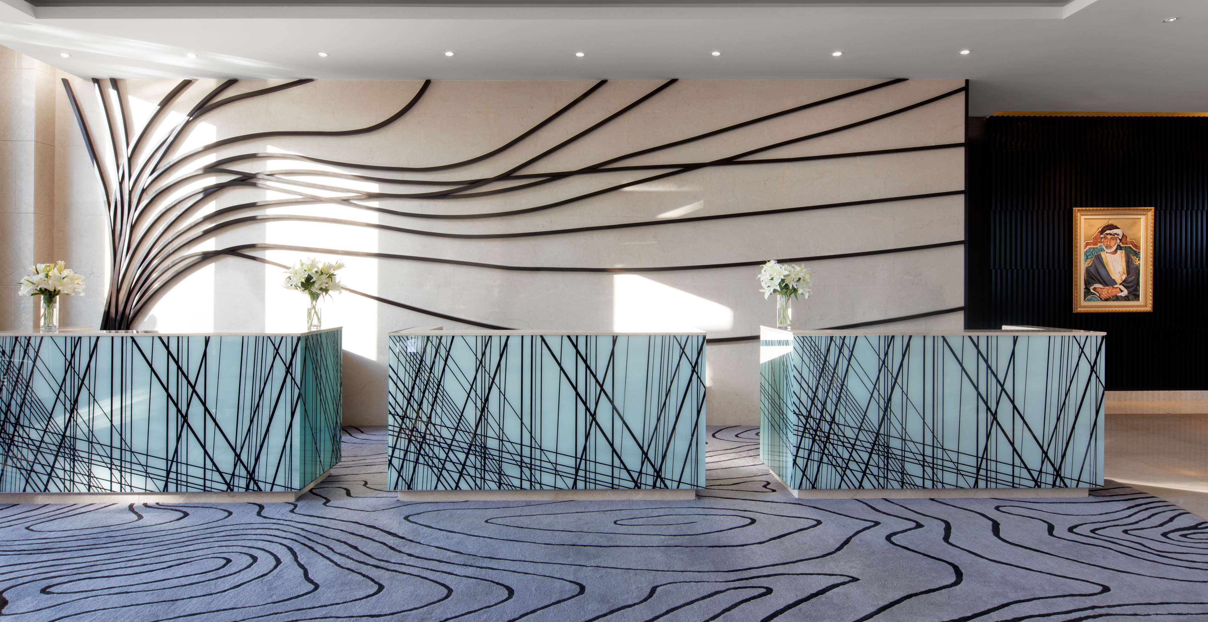 A modern reception area with a unique wall design, two reception desks, and a carpet with a wave pattern.
