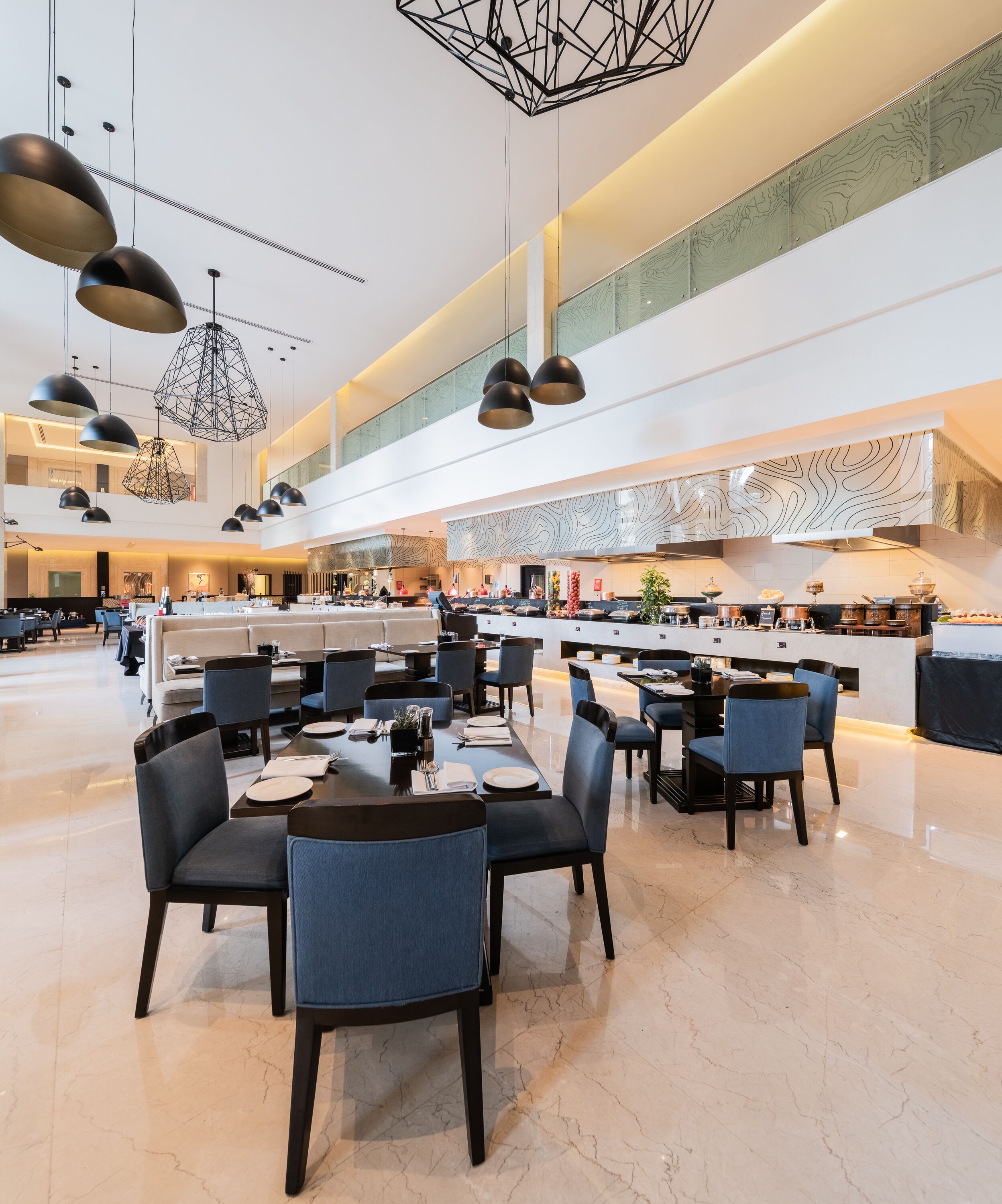 Un comedor amplio con muebles modernos e iluminación colgante.