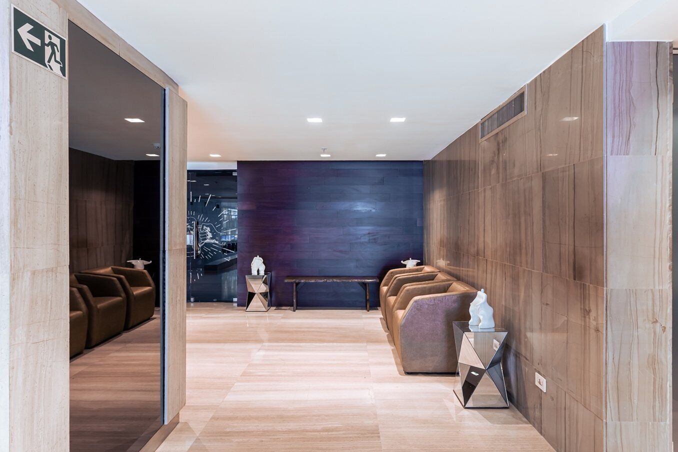 Un lobby moderno con una recepción, zona de estar y un reloj en la pared.