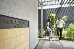 Entrada de un hotel con un letrero que dice "HOTEL REINTRINITY KANAZAWA".