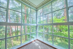 Una habitación con ventanas amplias que dan a un bosque.
