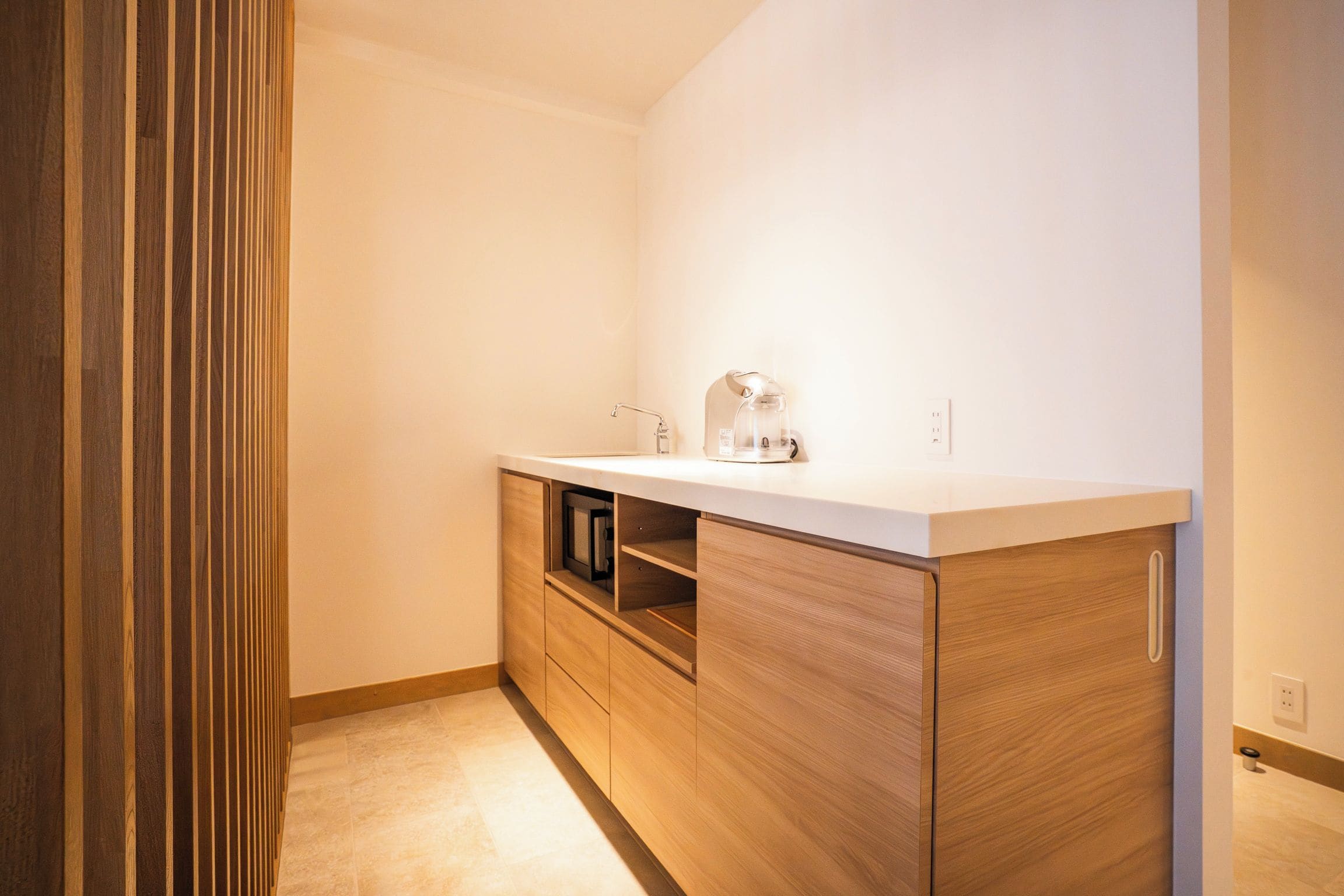 A small, modern bathroom with a wooden vanity, a mirror, and a shower area.