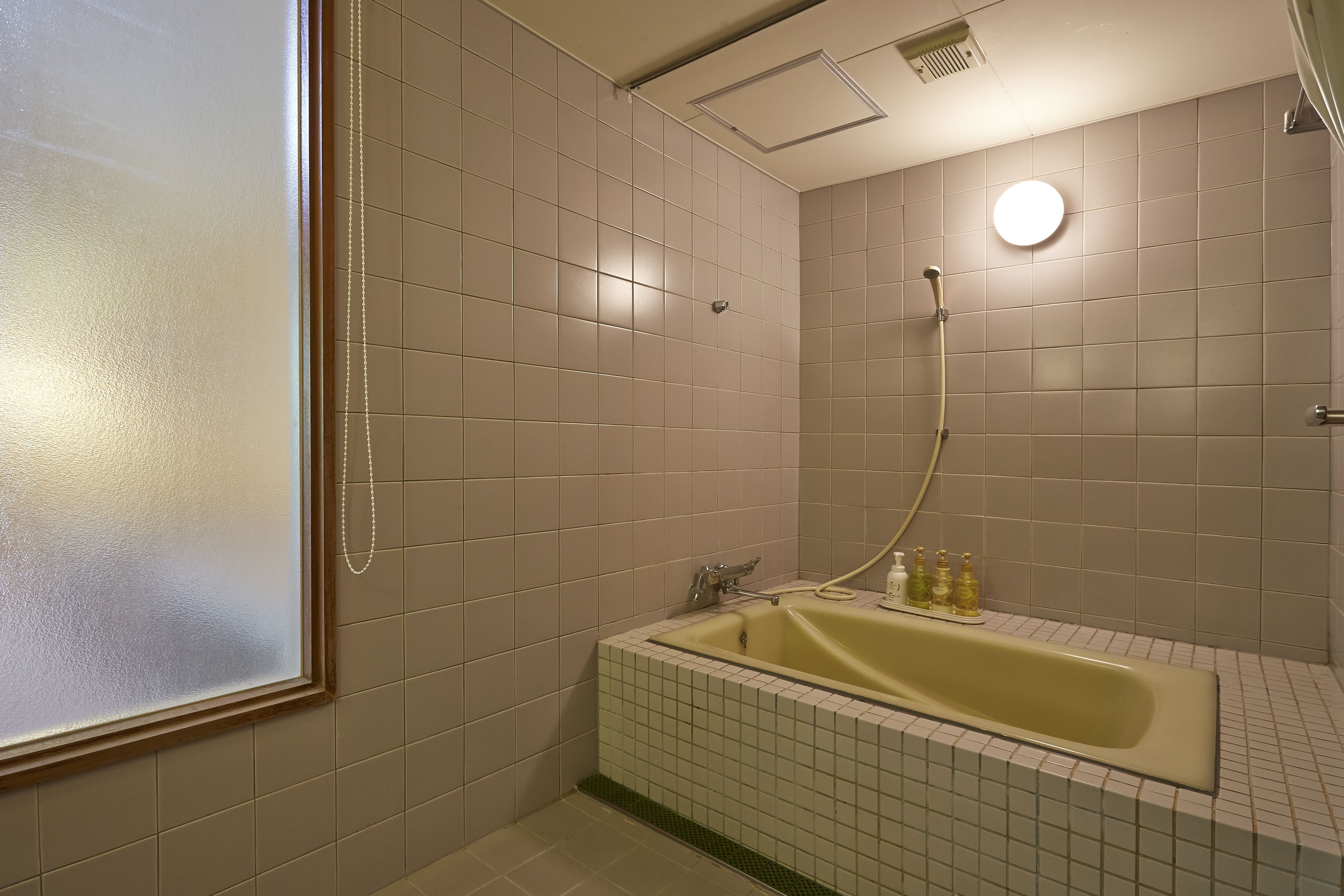 A bathroom with a bathtub, a shower, and a window.