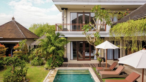A two-story villa with a swimming pool, outdoor seating, and lush greenery. - Lebak Bali Residence (Canggu)