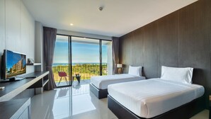 A modern hotel room with two beds, a TV, a desk, and a balcony with a view. - The Wind (Sattahip)