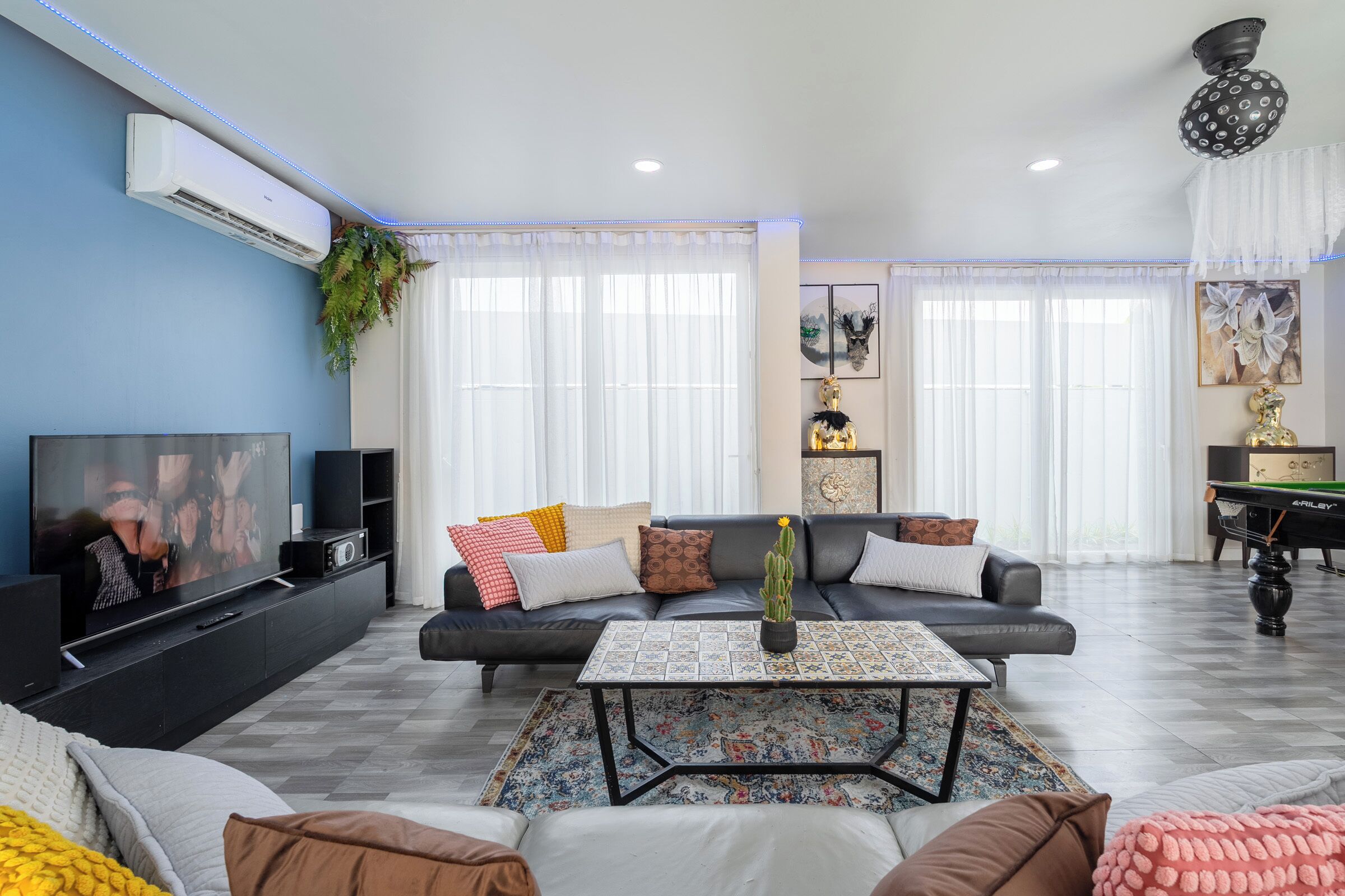 A modern living room with a sofa, coffee table, TV, and decorative items.