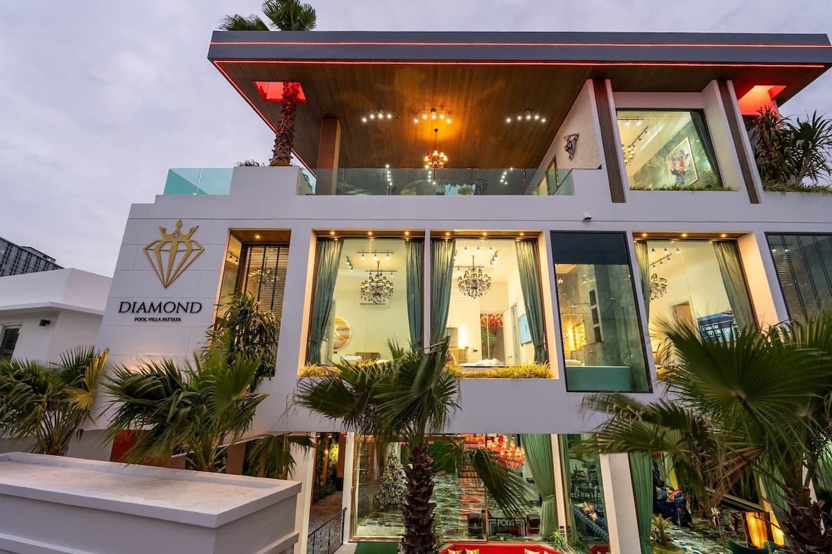 A modern hotel with a prominent "DIAMOND" sign, large windows, and a balcony with plants.