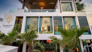 A modern hotel with a prominent "DIAMOND" sign, large windows, and a balcony with plants. - Villas In Pattaya (Pattaya)