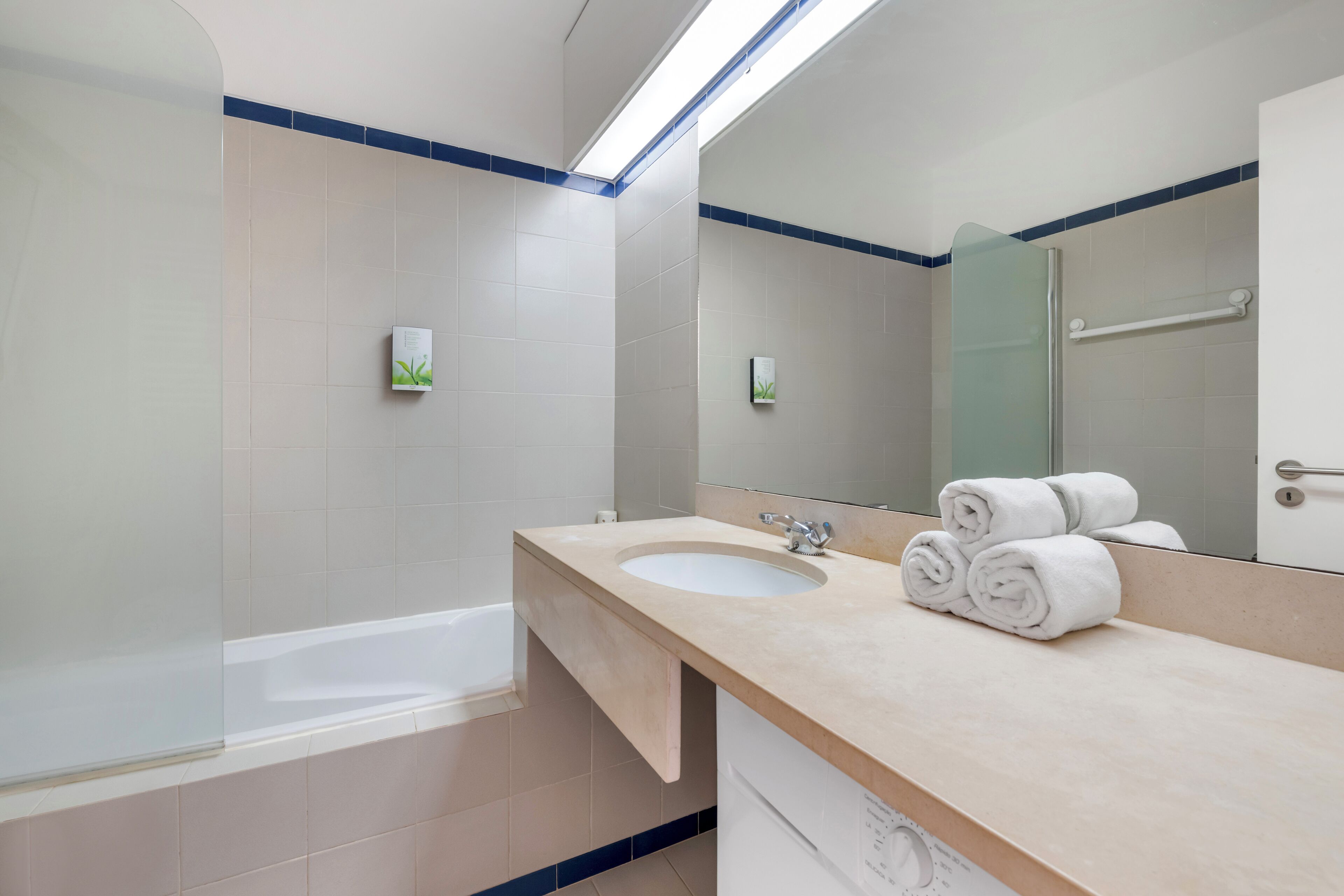 A modern bathroom with a bathtub, a sink, and a mirror.