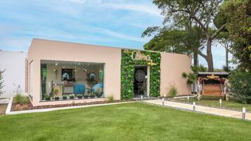 A spa named "Olma Spa" with a modern design, glass windows, and a green vertical garden.