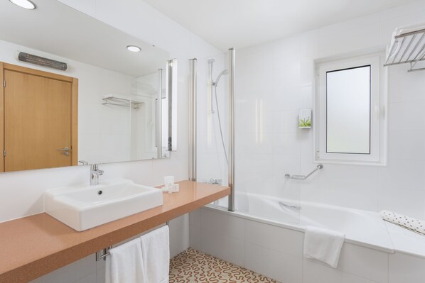 A modern bathroom with a sink, mirror, shower, and bathtub. - Vilar Do Golf (Loulé)