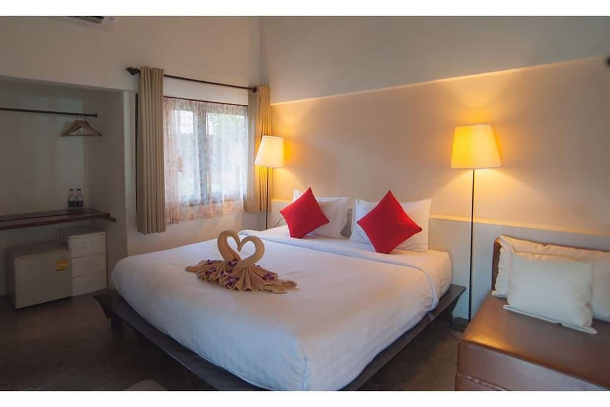 Una habitación de hotel con una cama grande, dos lámparas de noche, un aparador y un espejo.
