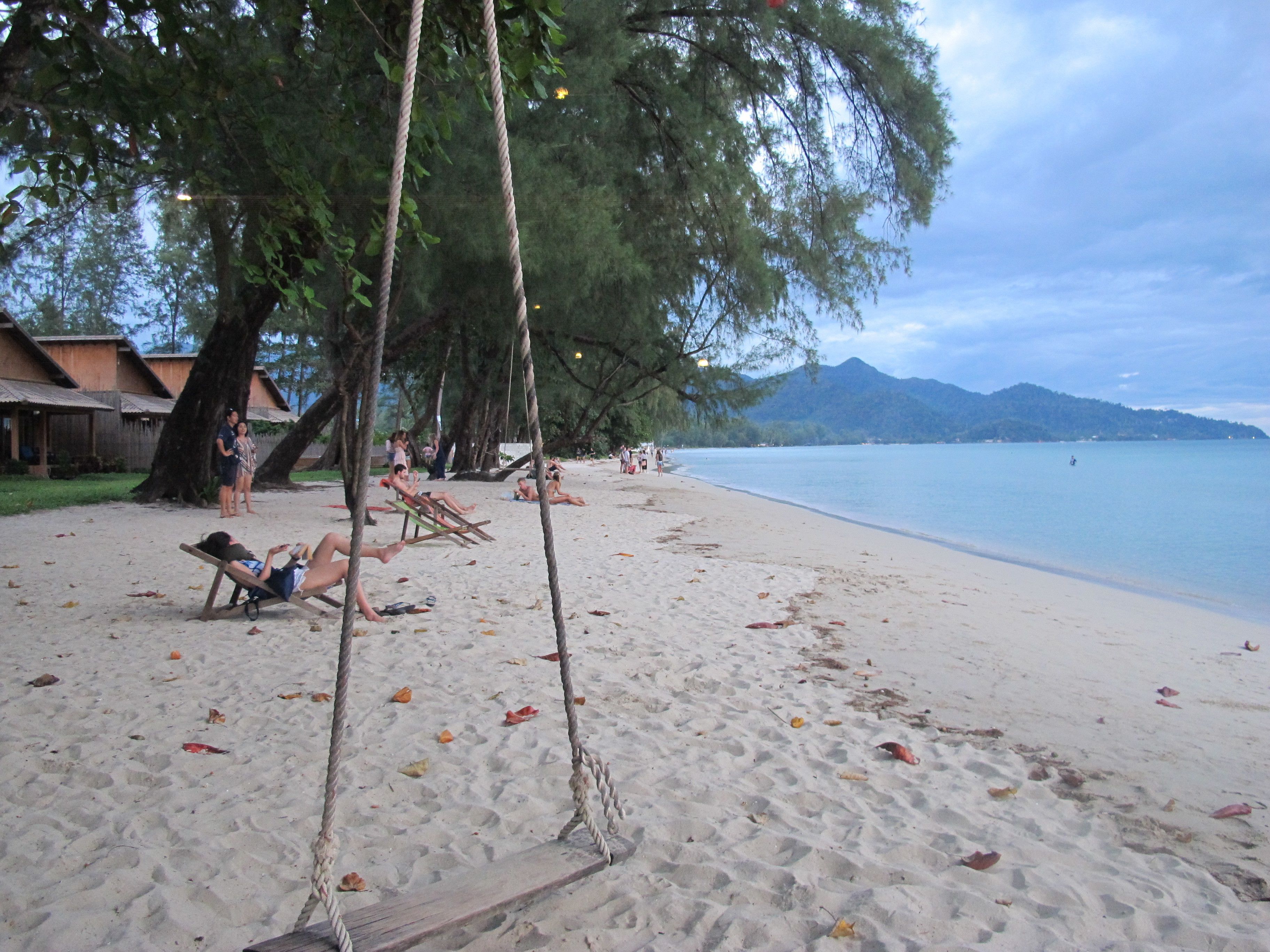 Una playa cerca, sillas reclinables de playa, sombrillas