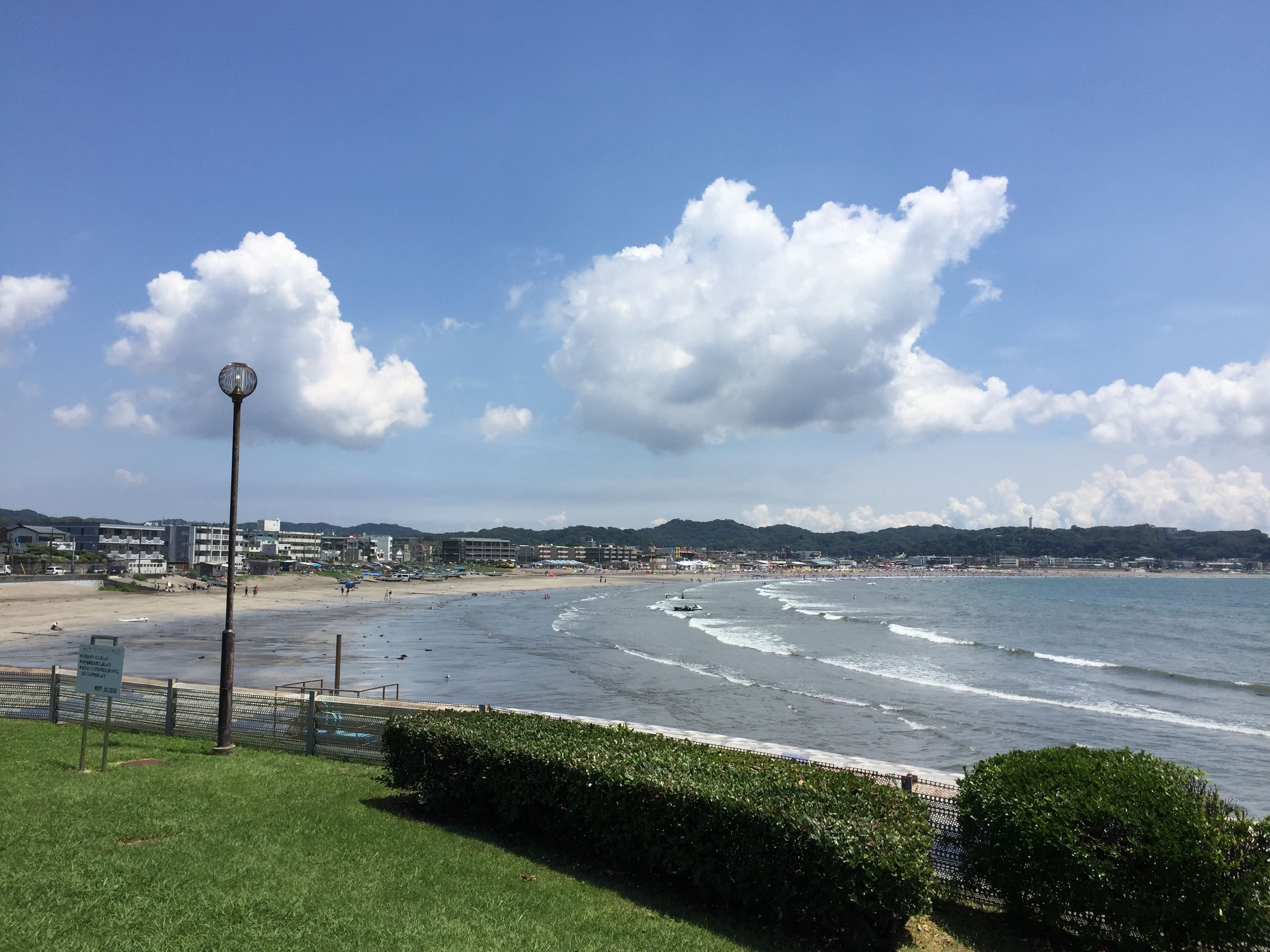 Vista costeira com praia, um lampião e um letreiro.