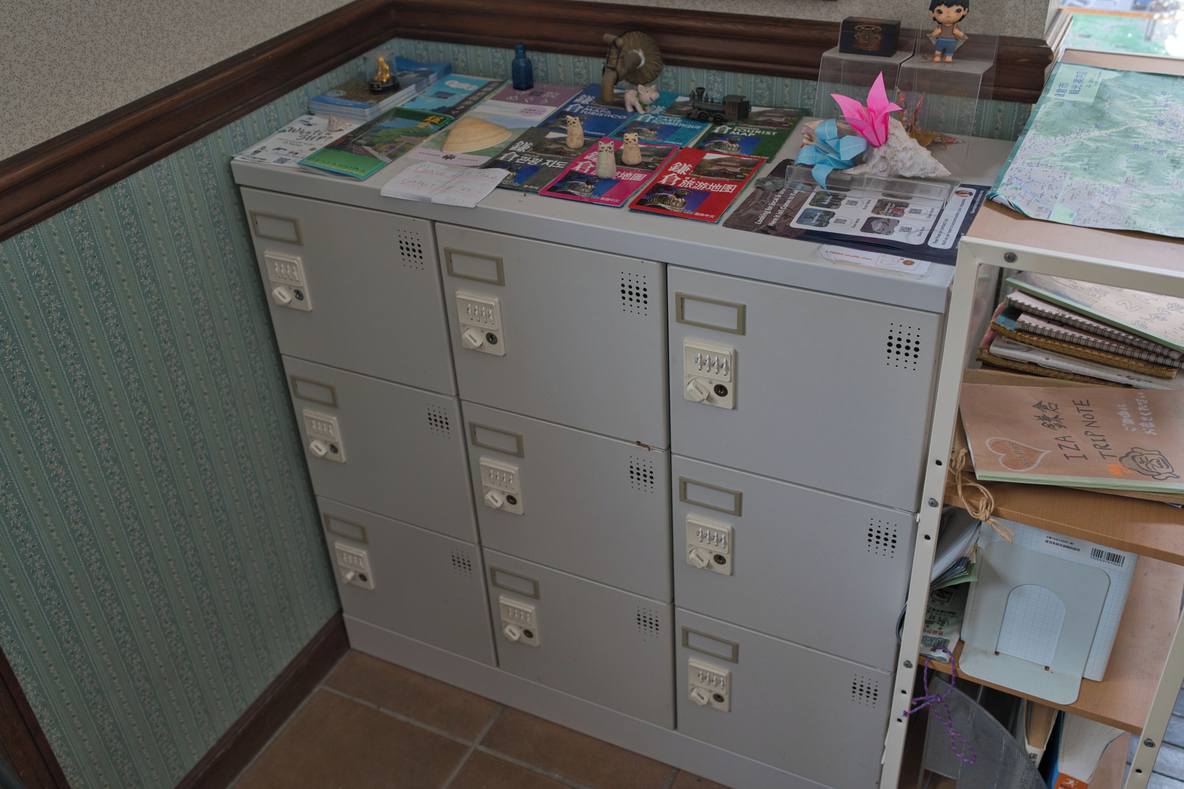 A storage area with multiple metal lockers, a wooden counter with various items, and a tiled floor.