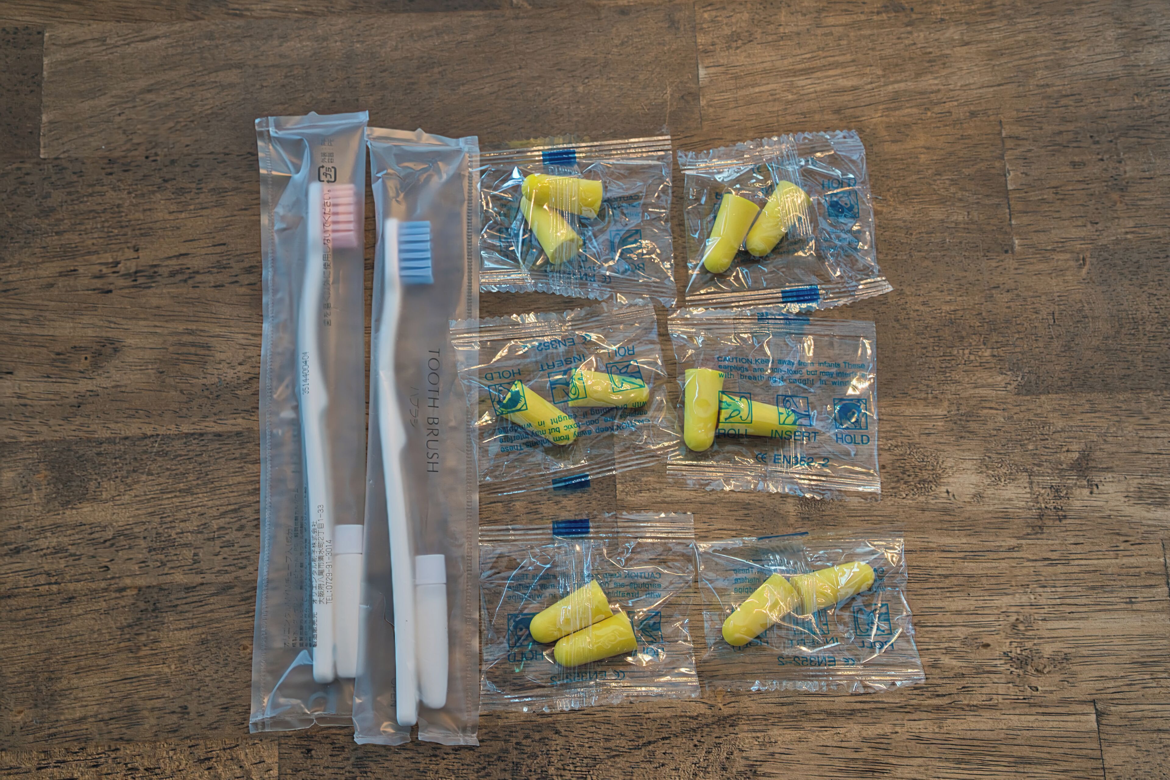 A wooden floor with several plastic packages containing yellow and white items.