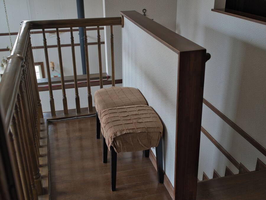 A wooden staircase with a bench at the bottom.