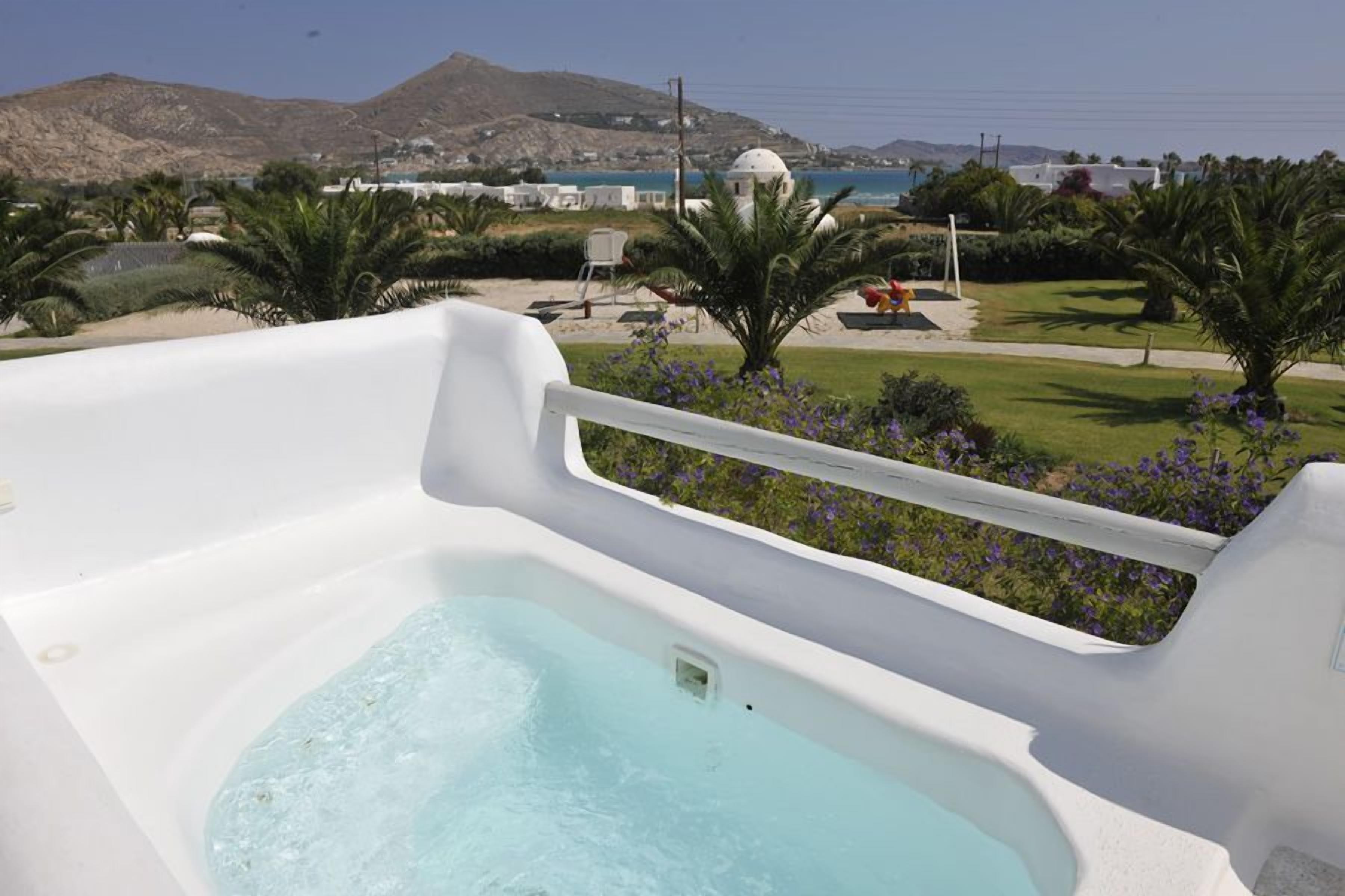 A hot tub with a view of a beach and mountains.