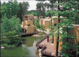 Un resort con varias construcciones, una fuente central y un puente que conecta diferentes zonas.