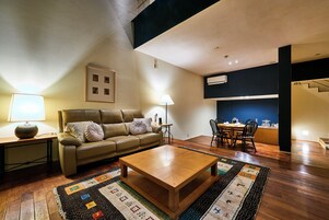 A living room with a sofa, coffee table, and a patterned rug.