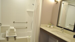 A bathroom with a bathtub, a toilet, a sink, and a mirror. - Holiday Inn Express & Suites Price by IHG (Price)