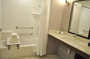 Une salle de bain avec une baignoire, des toilettes, un lavabo et un miroir.