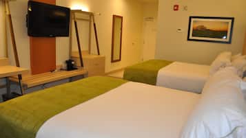 A hotel room with two beds, a desk with a chair, a television, a mirror, and a framed picture on the wall.