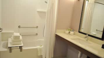 Une salle de bain avec une baignoire, des toilettes, un lavabo et un miroir.