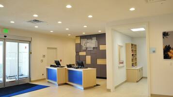 A reception area with a desk, computer, and a sign indicating a suite shop.