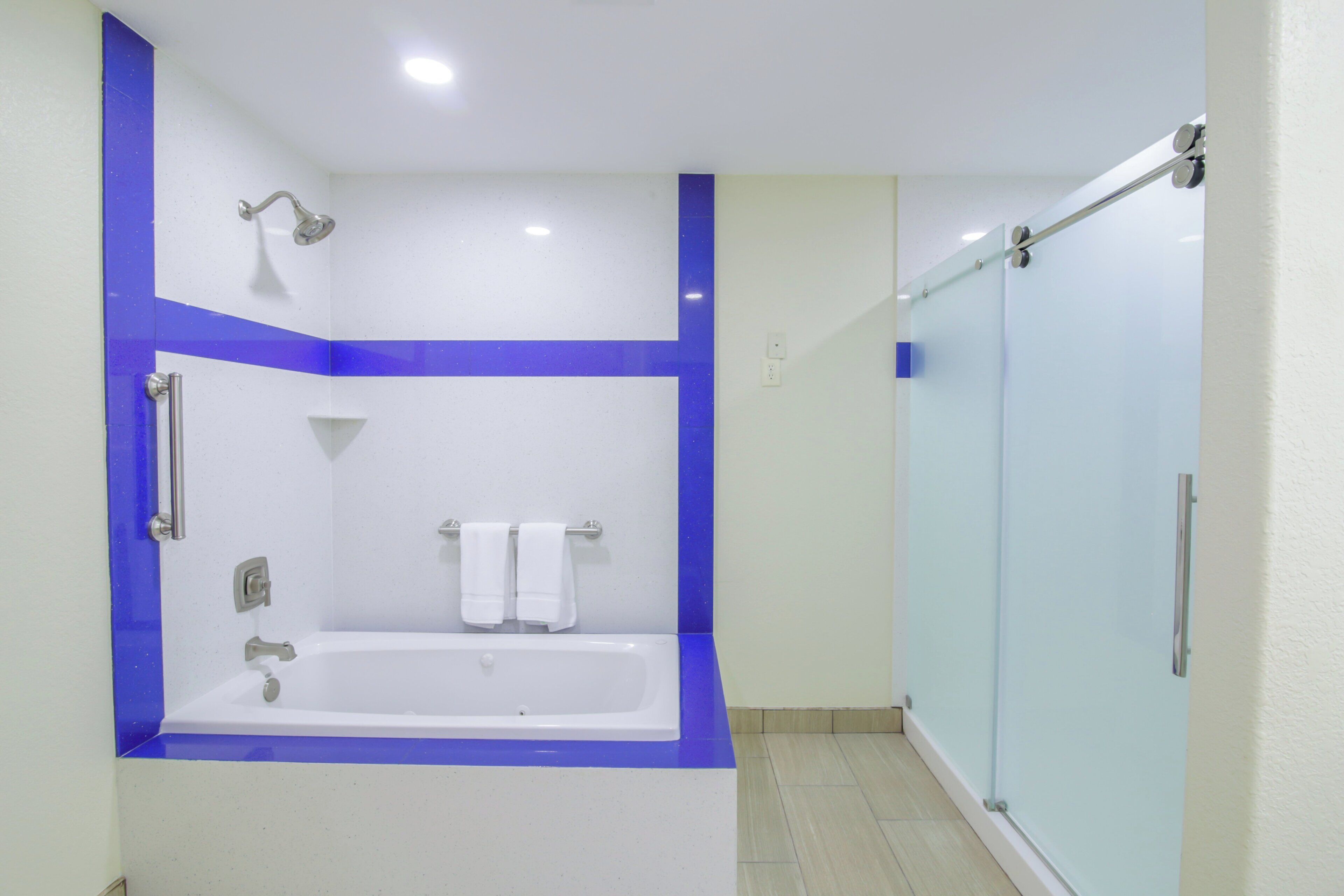 A bathroom with a bathtub, a shower, and a glass-enclosed shower area.