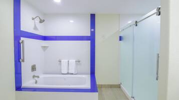 A bathroom with a bathtub, a shower, and a glass-enclosed shower area.