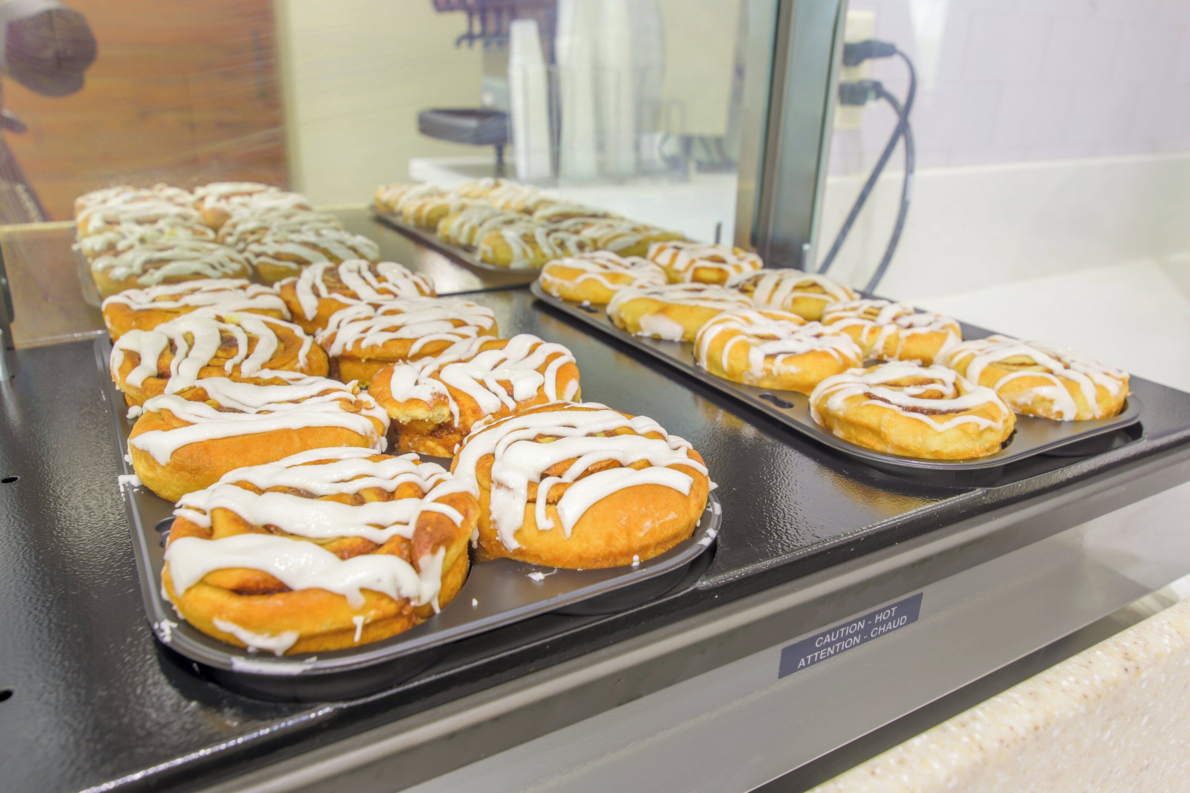 A tray of glazed pastries on a metal rack.