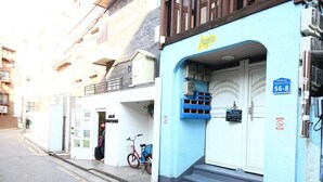 A building with a blue facade, a sign reading "Again," and a staircase leading to the entrance. - Again Seoul Guesthouse (Seoul)
