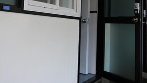 A hallway with a white door and a glass door, both with black frames. - Again Seoul Guesthouse (Seoul)