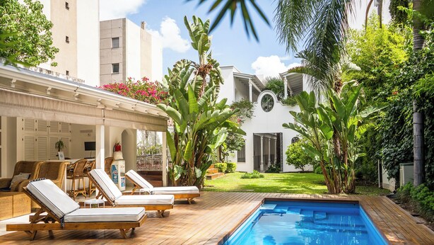 A poolside area with lounge chairs, a small pool, and lush greenery. - Villa Vicuña Hotel Boutique (Salta)