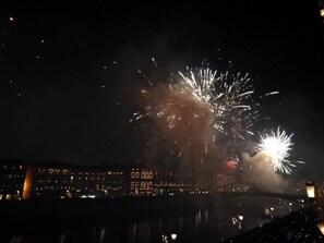 A nighttime view of a cityscape with fireworks in the sky.
