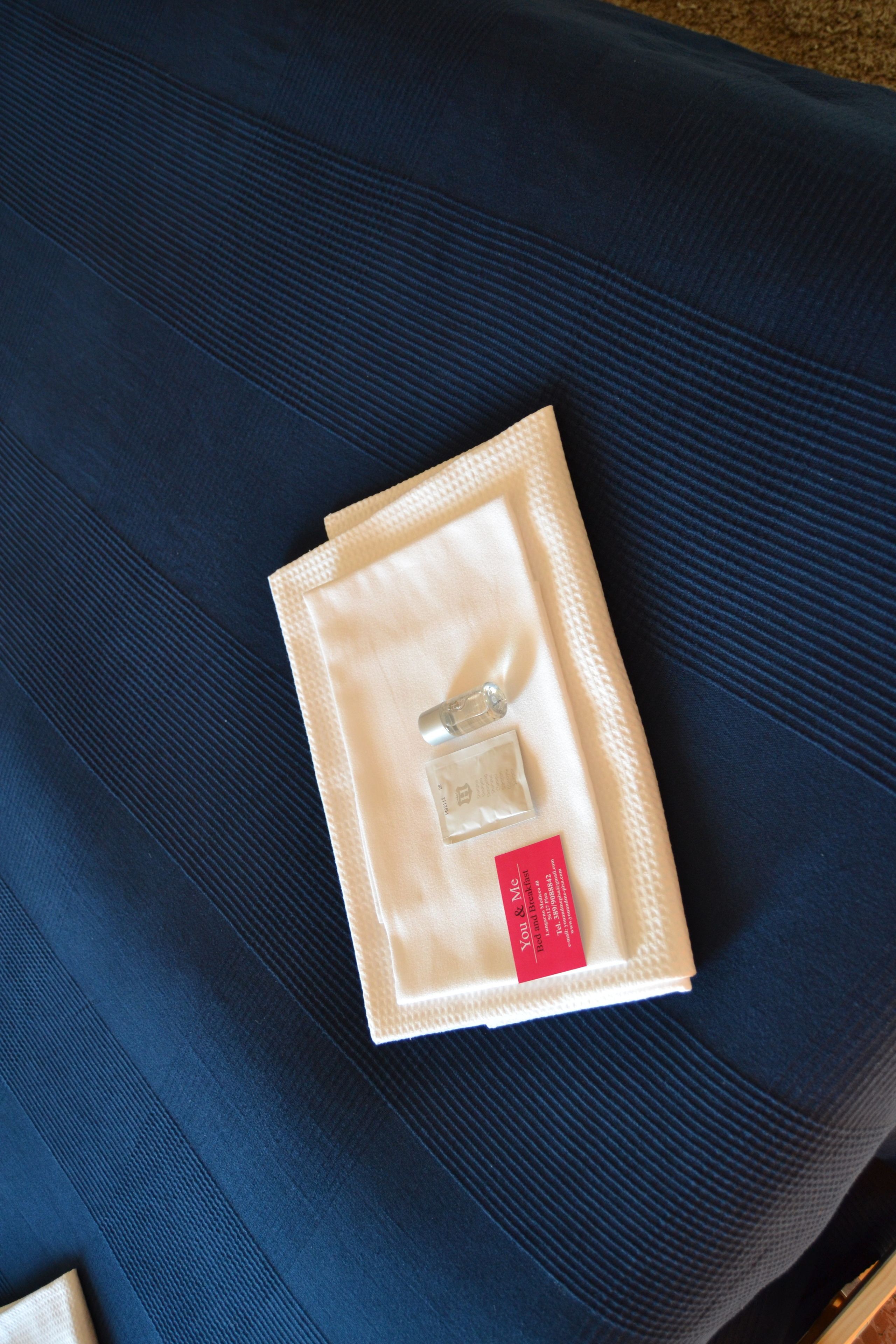 A neatly folded beige item with a red label on a dark blue fabric surface.