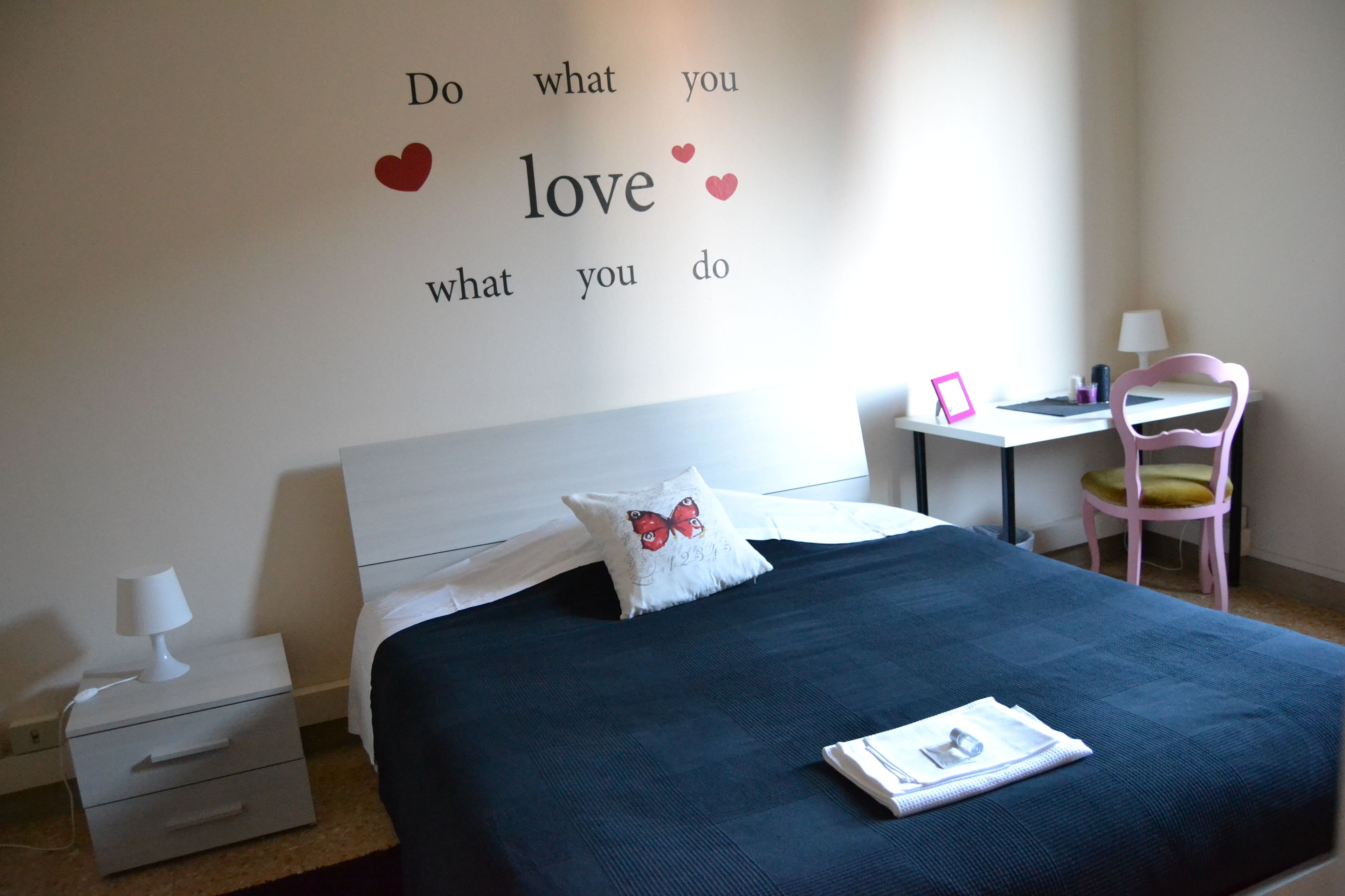 Ein ordentlich eingerichtetes Schlafzimmer mit einem Bett, einem Schreibtisch und einem Stuhl.