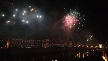 A nighttime view of a waterfront area with buildings and a bridge.