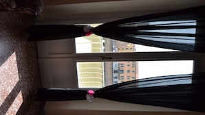 A room with a large window, a bed, and a view of buildings outside. - You & Me (Pisa)