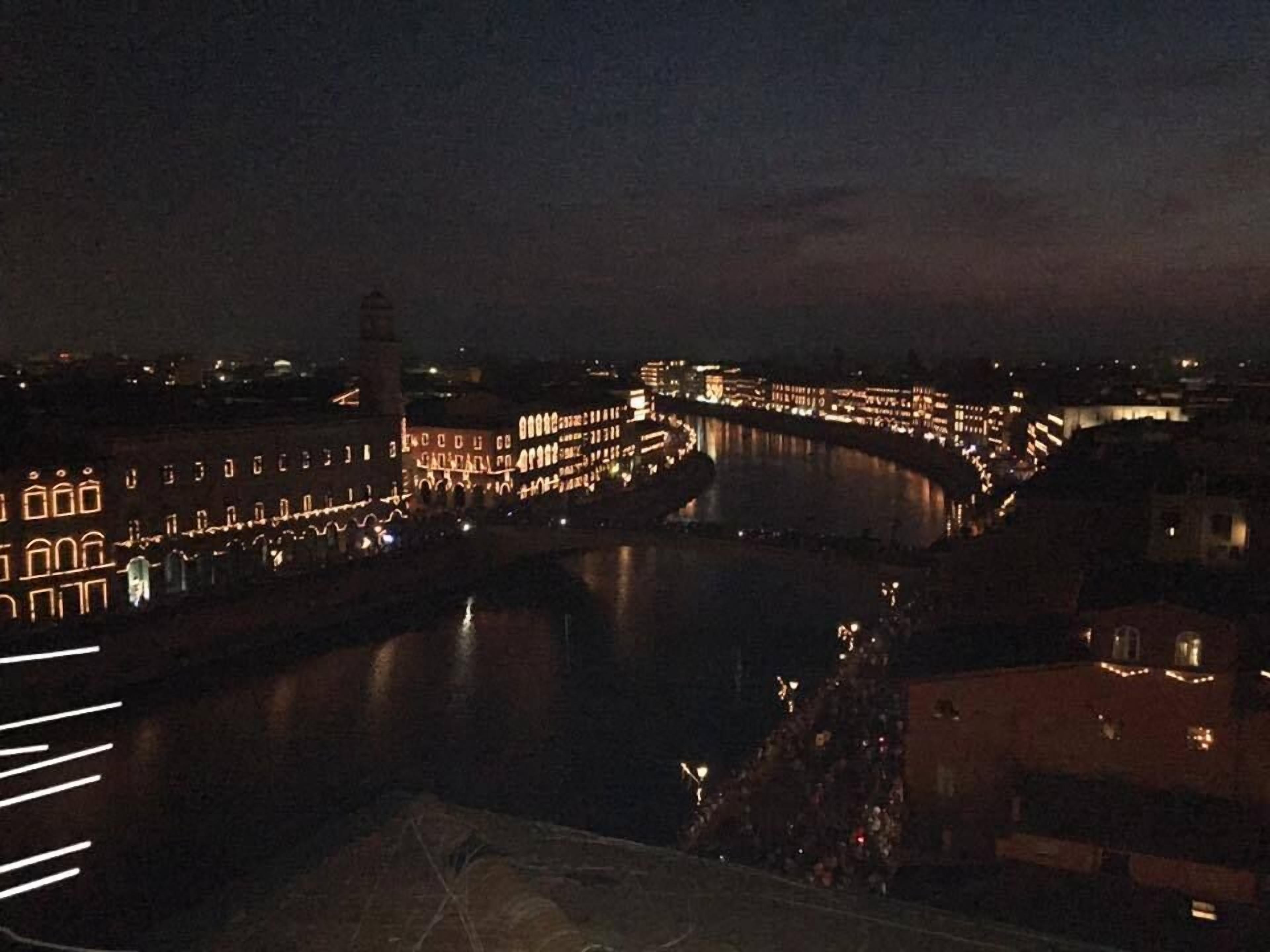 Une vue nocturne d’une rivière, avec des bâtiments illuminés le long de ses rives.