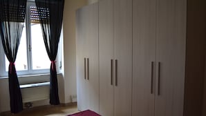 A bedroom with a bed, a wardrobe, and a window with curtains. - You & Me (Pisa)