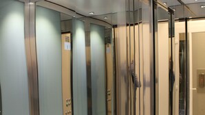 A modern elevator with glass panels and a metallic finish. - Hotel Eco del Mare (Massa)